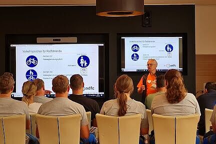 Theorie Präsentation mit Verkehrsschildern und Zuhörenden